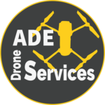 Logo de l'entreprise ADE Drone Services : un drone volant au-dessus d'une scène avec des bâtiments et des paysages